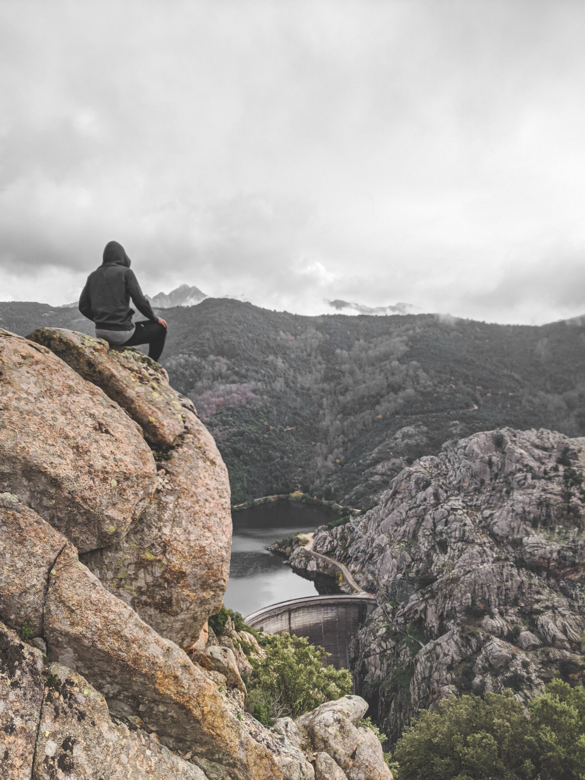 Un hombre sentado sobre una montaña reflexionando sobre el despertar espiritual